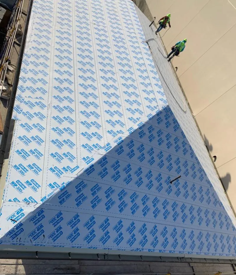 Professional roofers installing underlayment on a metal roof in Perris